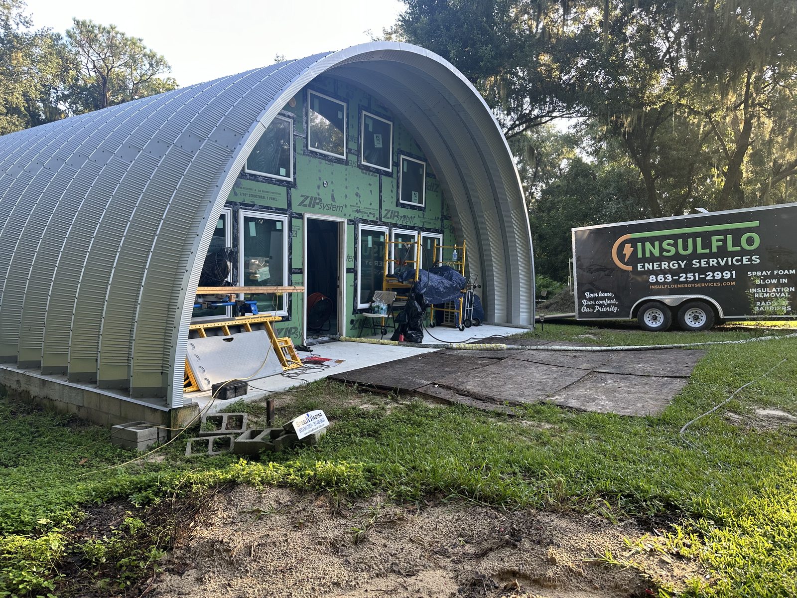 Insulflo spray foam rig parked outside a pole barn job site in Polk County