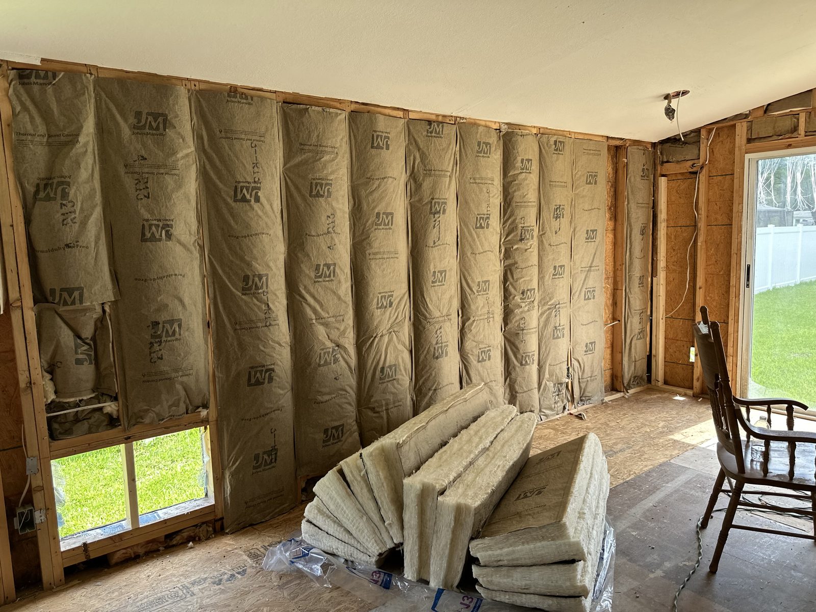 Batt insulation fitted between wall studs during a residential retrofit