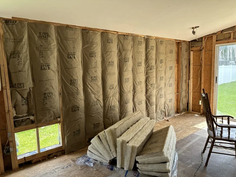 Batt insulation fitted between wall studs during a residential retrofit