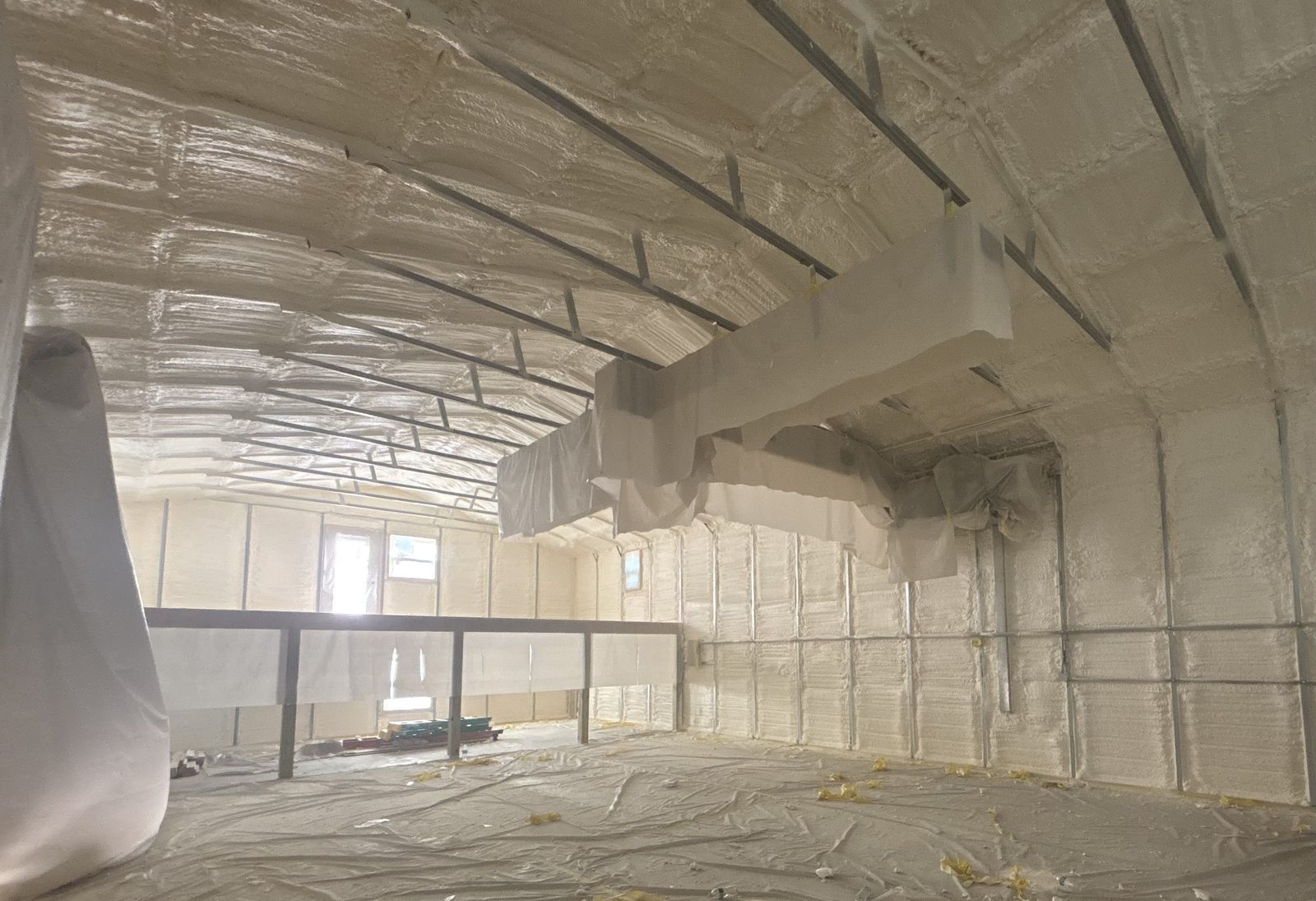 Closed-cell spray foam expanding to fill wall cavities between studs